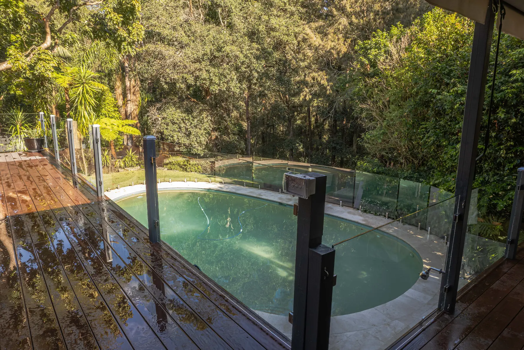 Garden pool glass fence deck view.