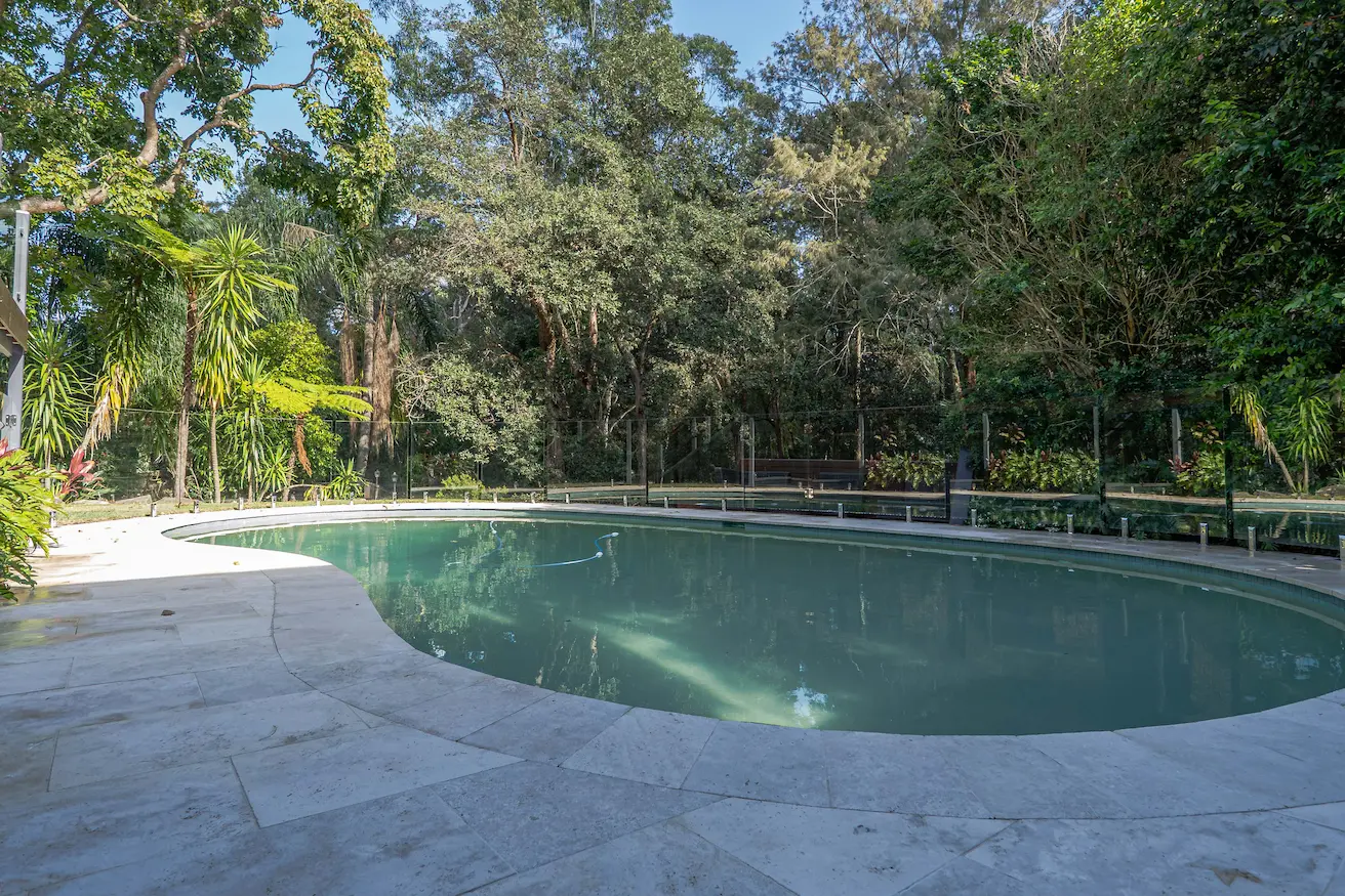 Garden pool glass fence wide view.