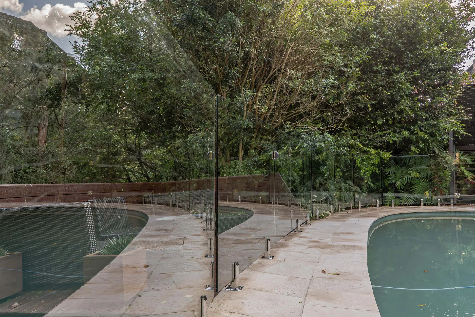 Glass pool fence curved paving wide.