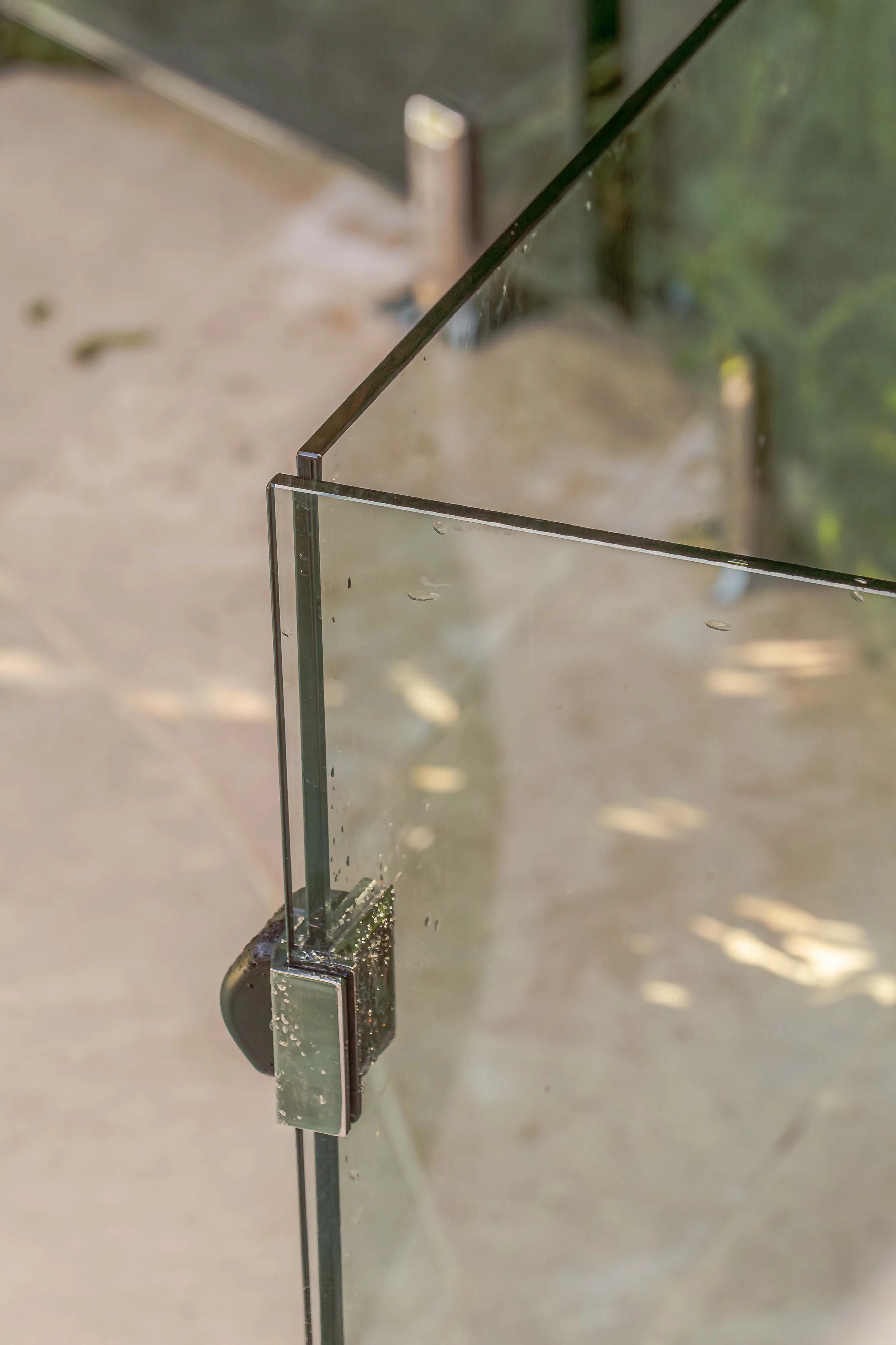 Glass pool fence panel join close up.