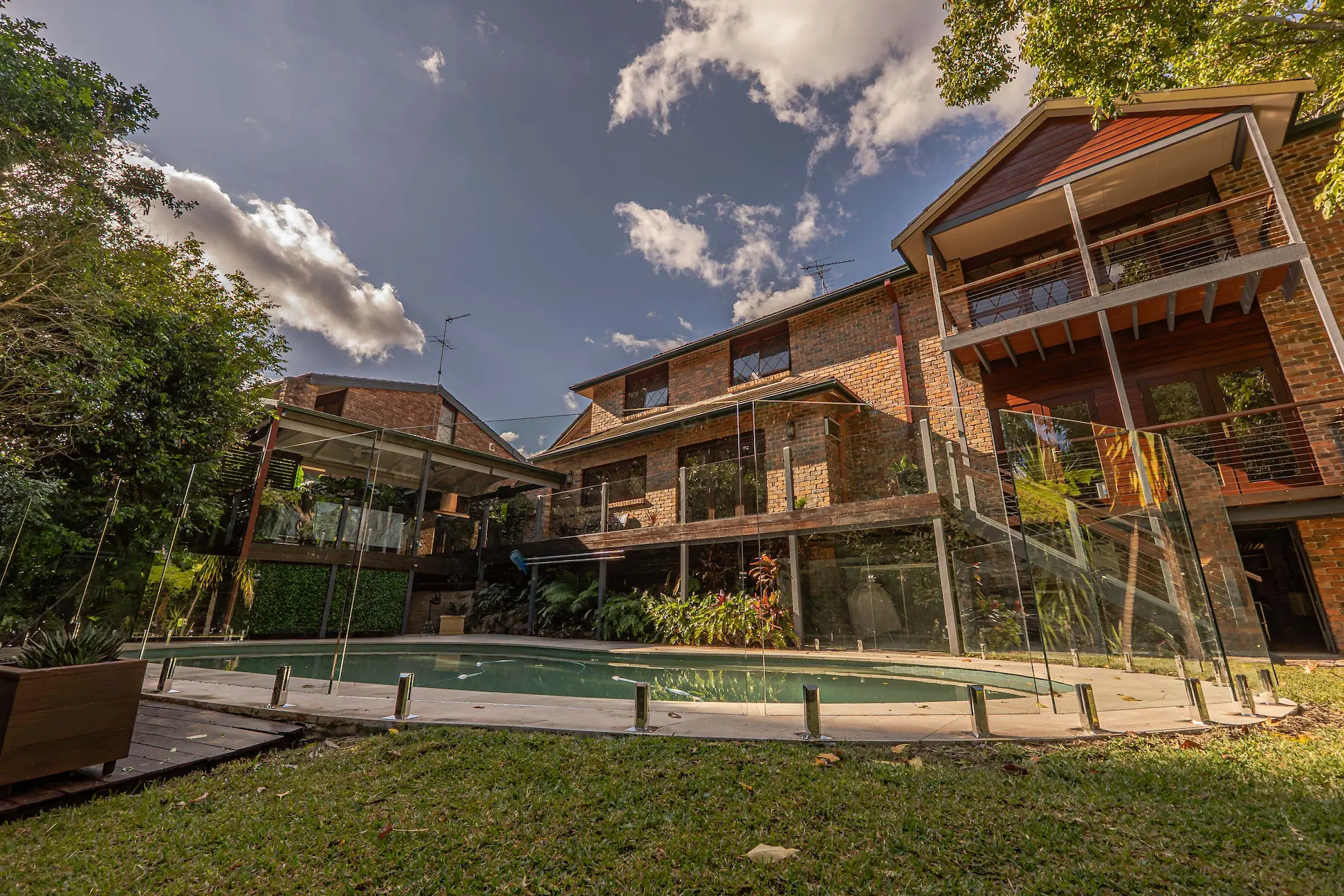 Pool glass fencing house lawn wide.