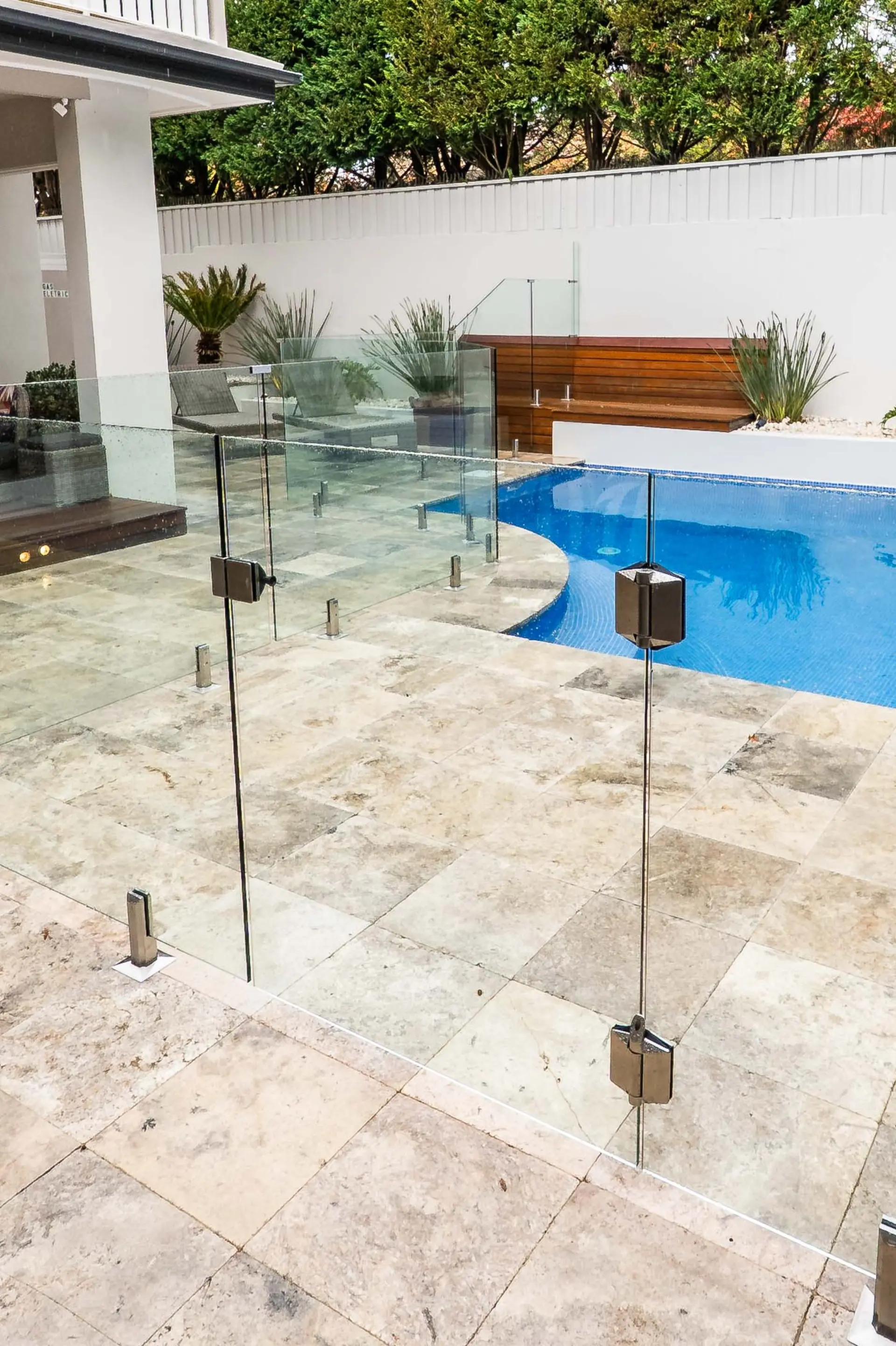 Glass pool fence stone paving.