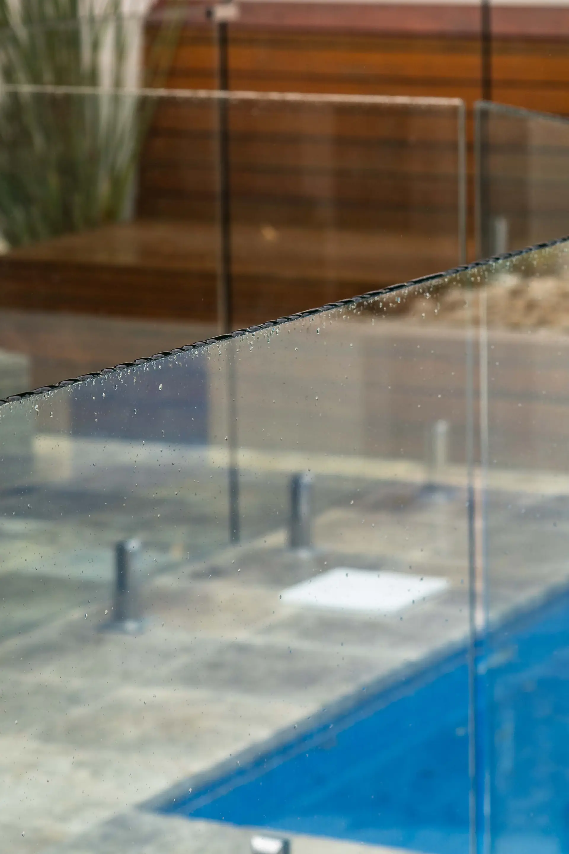 Glass pool fence water reflection.
